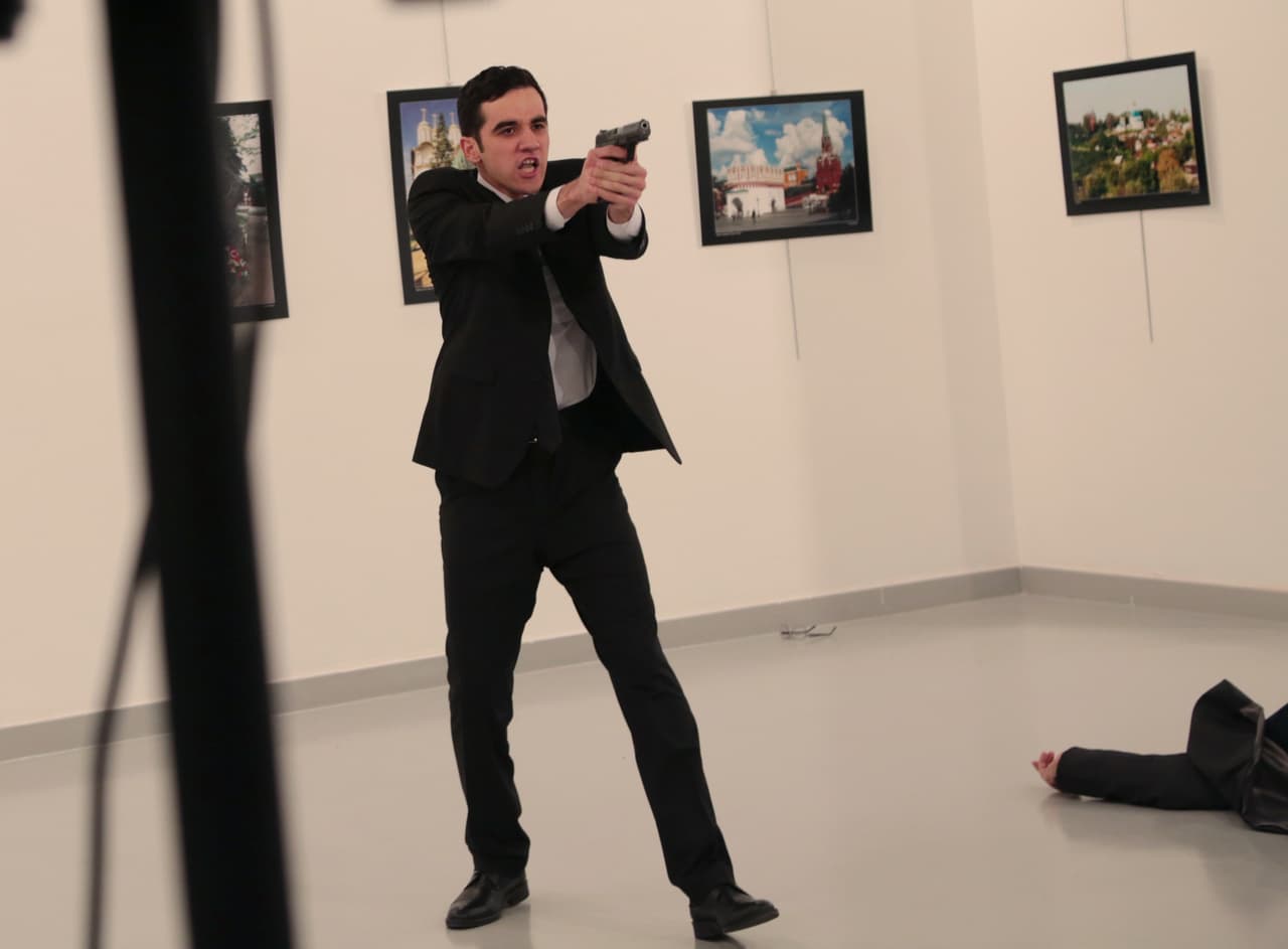 Los asistentes al evento donde fue el atentado se alejan del pistolero que asesinó al embajador. El asesino parece que logró ingresar a la galería de arte con una identificación de la policía.
