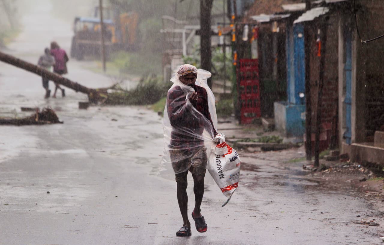 Un hombre camina bajo la lluvia que llevó Amphan a Bhadrak, al noreste de India. El ciclón comenzó a tocar tierra el miércoles por la tarde entre Digha, un destino turístico en Bengala Occidental, y las Islas Hatiya, Bangladesh. 
<br>