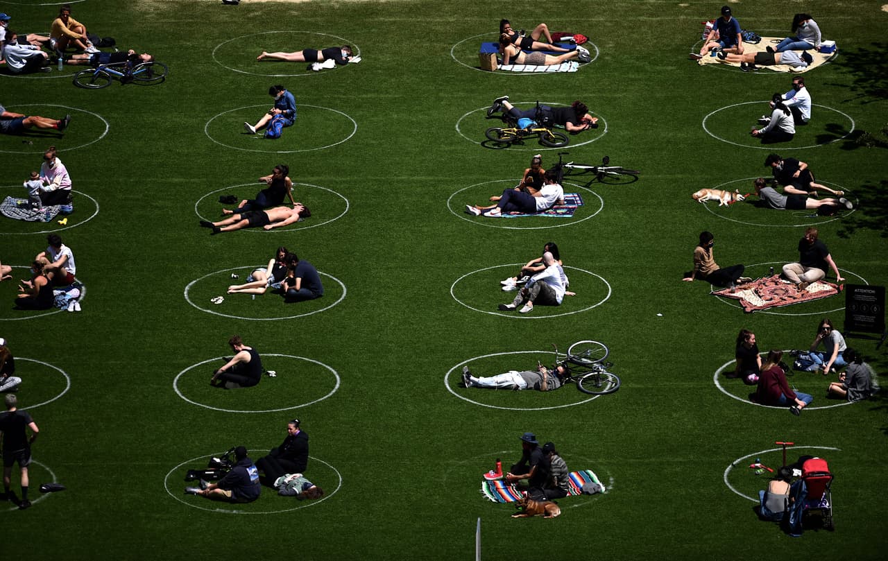 <b>Los espacios de separación en los parques (17 de mayo). </b>Los visitantes ocupan los espacios marcados para permanecer a seis pies de distancia en el Domino Park de Nueva York. Una medida de la ciudad para fomentar el distanciamiento social.