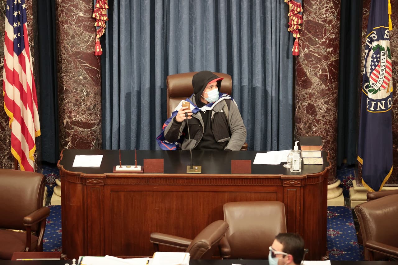 <b>Jugando a liderar el Senado</b>
<br>
<br>Esta fotografía capturó el momento en el que uno de los partidarios de Trump se sentó en el puesto principal del Senado de Estados Unidos. Allí se tomó algunas fotografías.
<br>